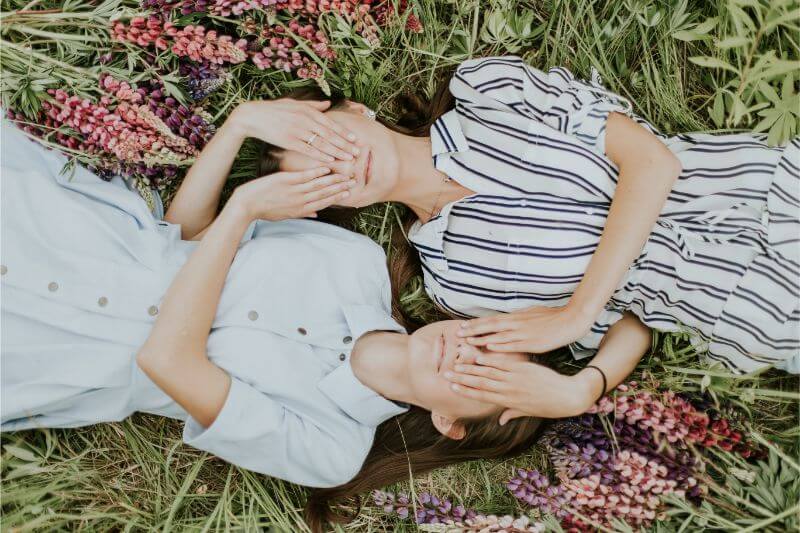 Girls lying on the grass and blindfolded