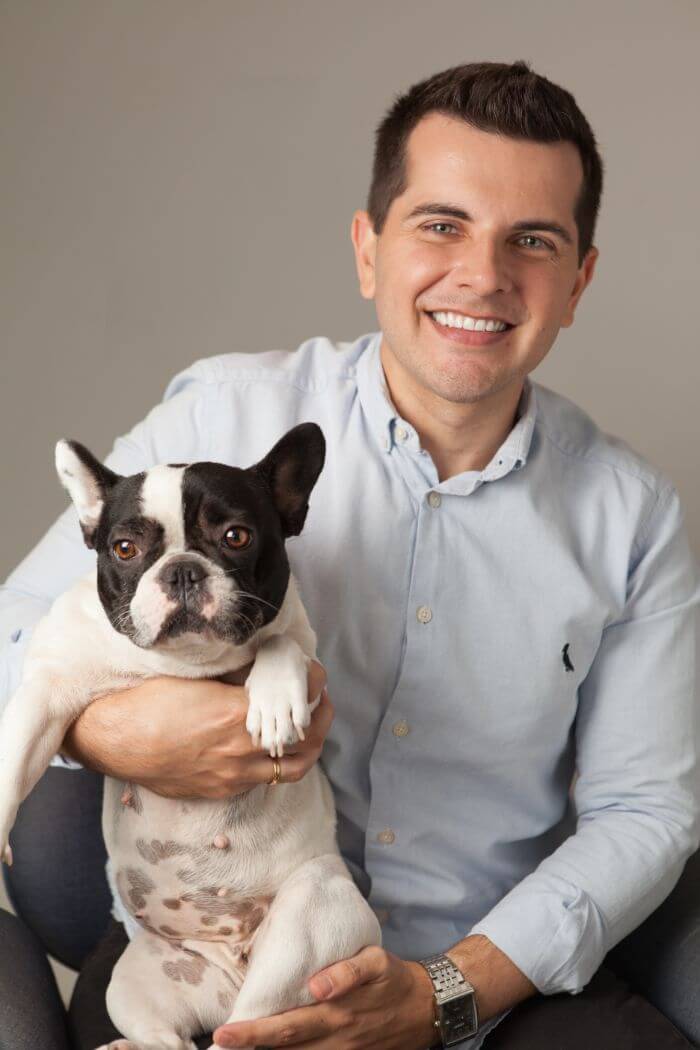 smiling man holding French bulldog