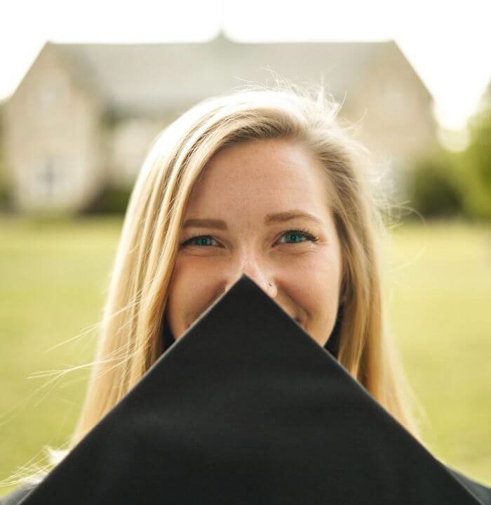 woman covering her face with black mortar board