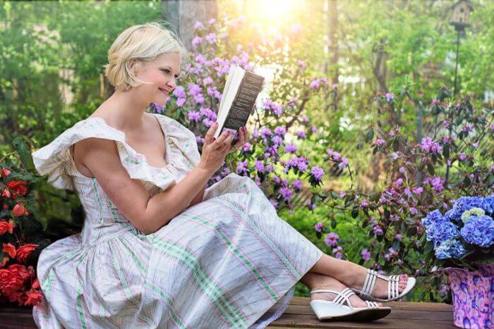 Woman reading a book in a flower field